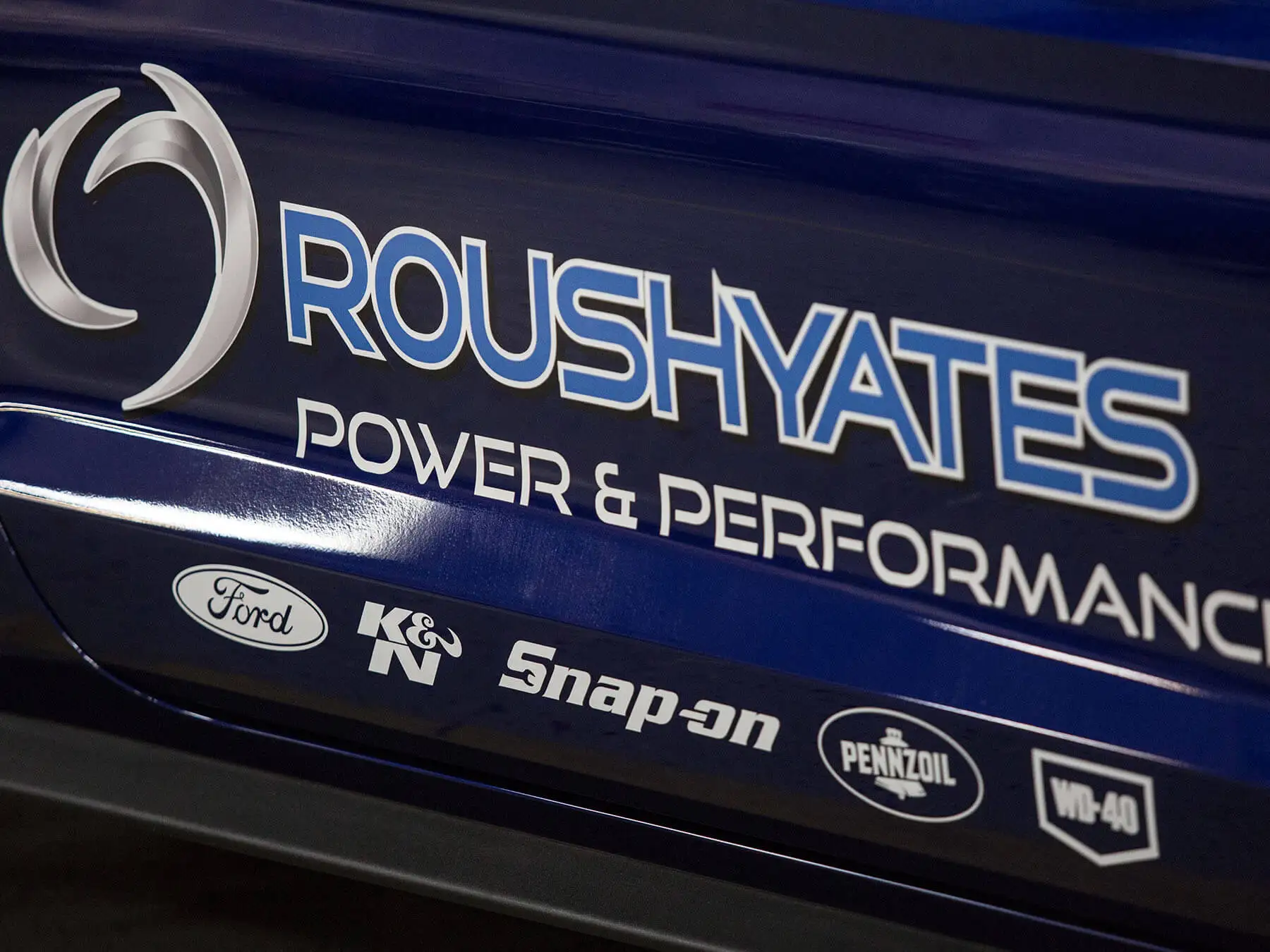 Close up on the blue roushyates logo