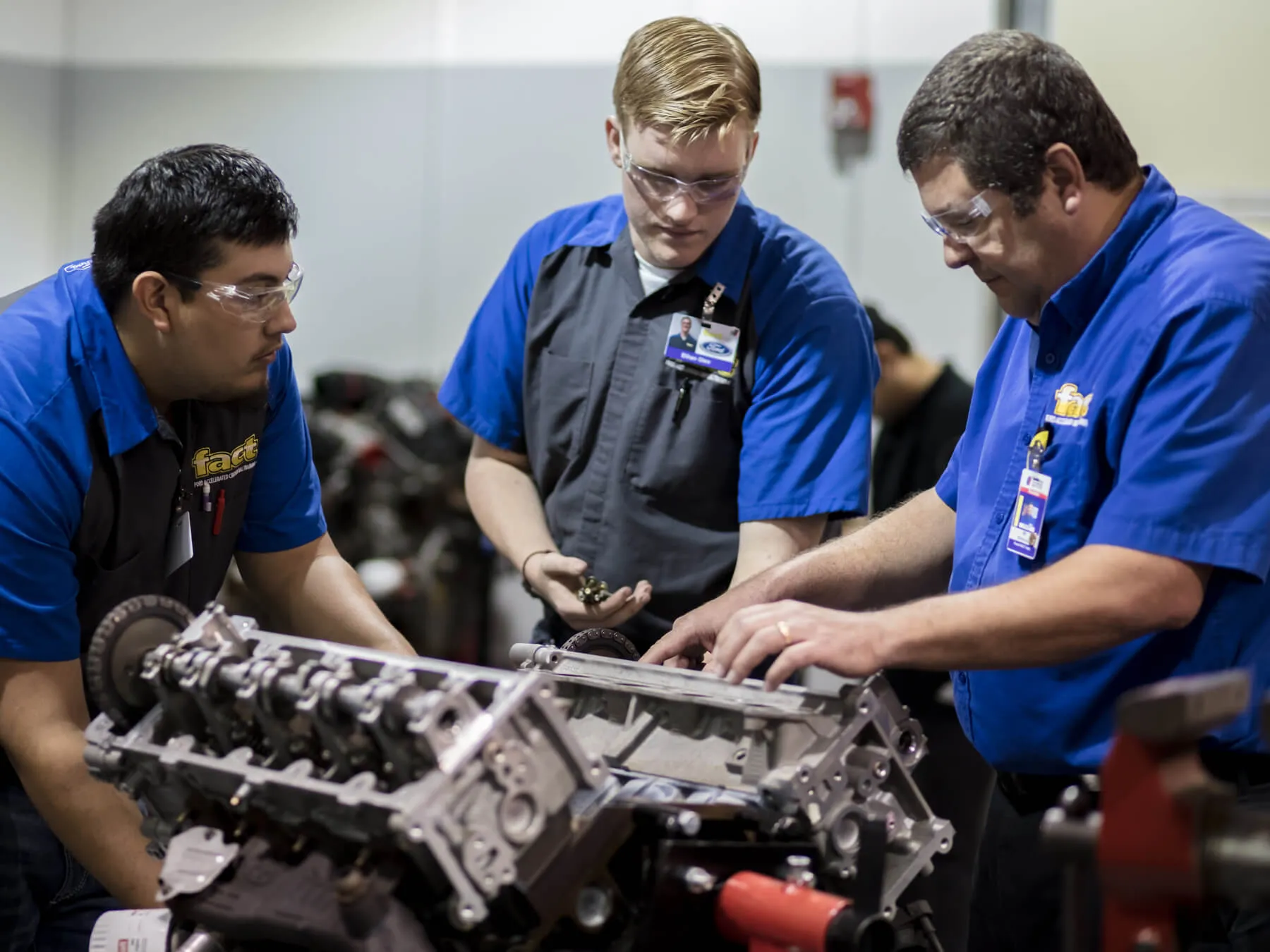 UTI instructor and students working on an engine in the ford auto lab